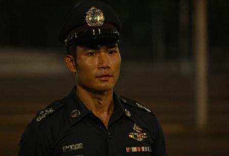 upper body, cinematic still of 30 year old handsome muscular Thai man in police uniform and hat, standing in Bangkok streets, highly detailed, intricate details, shallow field of depth, cinematic lighting