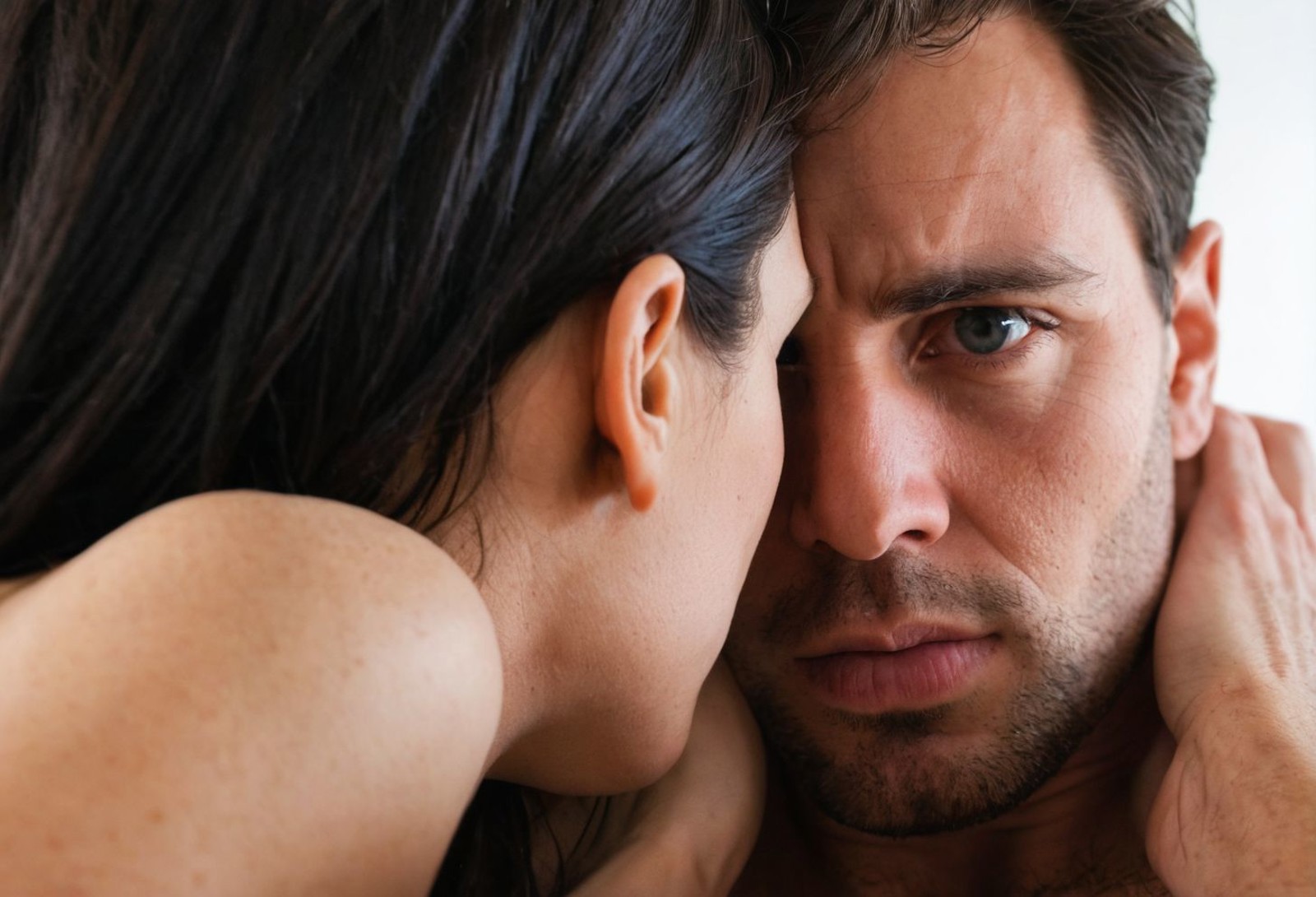 A woman with dark hair is shown in a close-up shot, her face partially obscured by the man's body. Her eyes are focused on...