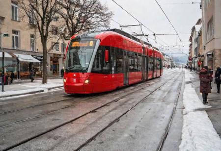 raw photo,( shallow depth of image:1.2), (minimalistic:1.1), outdoors, wide shot of the most richest swiss downtown in winter, luxury, fancy, people, snowy, cloudy, red tram, 38 mm photograph, backlit