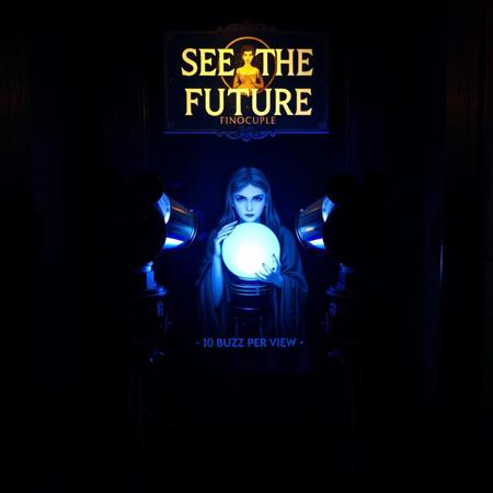 A coin operated stereo telescope binocilars in closed dark room with sign decorated with image of a female oracle holding crystal ball and text "SEE THE FUTURE" and "10 BUZZ PER VIEW"