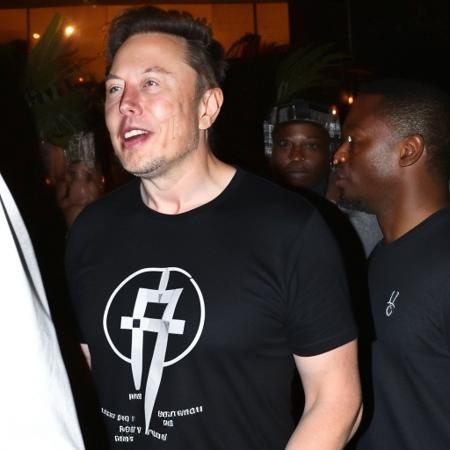 elonmusk person ((wearing a shirt with a /"@"/ symbol)). Dancing on the outdoor patio of a nightclub in Detroit.