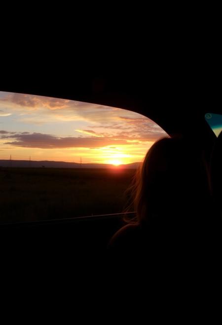 My days end best when the sunset gets itself behind,
That little lady sittin' on the passenger side,
It's much less picturesque without her catchin' the light,
The horizon tries, but it's just not as kind on the eyes