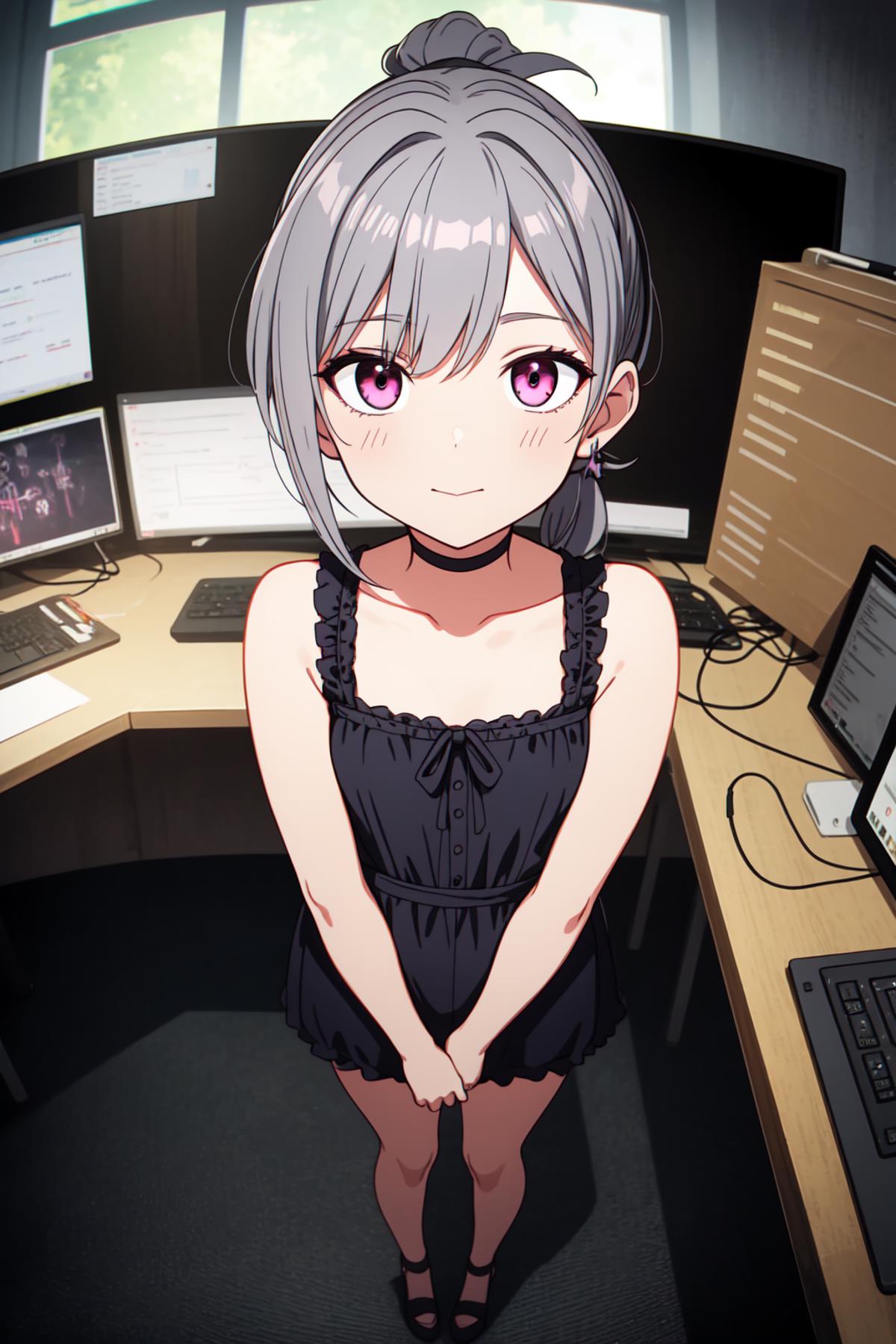 A young girl in a black dress sitting in a room with computer monitors.