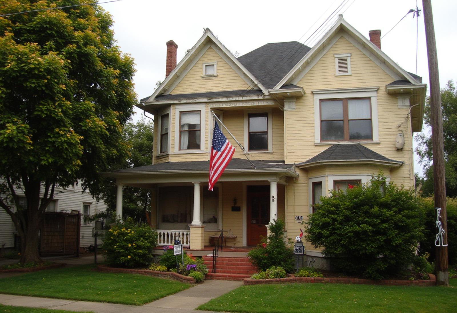 Amateur photography of american style house, american flag, front lawn ,Casual, f/<aperture>, <other tags: like low light, slight blur, slight overexposure, warm tones, cluttered background>, jpeg artifacts, on flickr