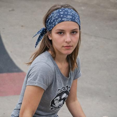 portrait of a skater girl, sk8ter girl, Casual, cool, rebellious, skateboard-toting, street-smart, athletic, independent, trendy, daring, bandana, mid riff, back ground skate park