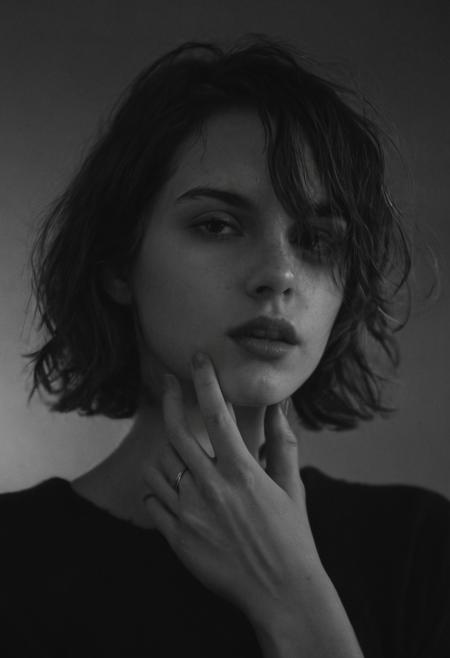cinematic, black contrast, hazy, motion blur effect, closeup, french girl, shot with flashlight, bright face,  pale skin, goddess face, hair down, cute, short messy hair, young, black background, face blurred, captured with slow shutter speed,  film grain and noise, sexy women in a black pullover, ring in her finger, perfect fingers, big lips, slim, jawline, short , hand on chin,looking away, background noise, dark shadows,    in black and white, high noise, messy short hairs  face covered with hair.