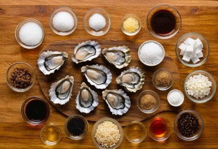An overhead shot of the ingredients used to make oyster sauce, including oyster extracts, sugar, salt, and water. The components should be arranged neatly on a kitchen counter or cutting board, 8k resolution,