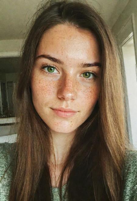 instagram selfie , a 23 year old gorgeous woman , slight smirk, detailed skin face and eyes , natural lighting , at home , long hair, low contrast, natural face , freckles , brunette hair , green eyes