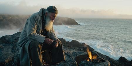 (full shot, distant, whole body) , (sunrise, god rays), old rugged fisherman, long white beard, torn dirty gray coat, dirty beany, sitting on old wodden stool on rock, campfire, small pot, looking at sea, beach, stormy, dense fog, rocks, (spindrift, spray), cinematic, rocks in foreground,