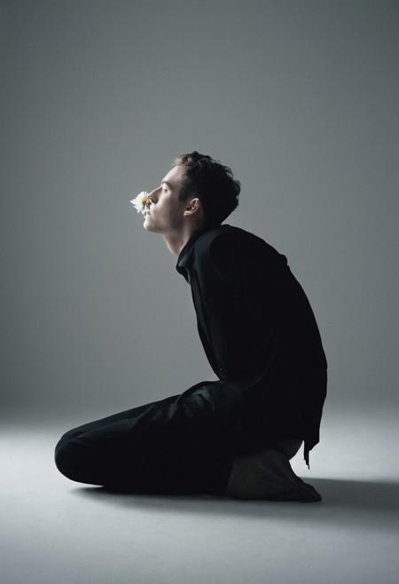cinematic film still fashion photography portrait of 1man, sitting on floor with head down, looking sideways, front, upside down, holding a single flower, double exposure, multiple hazy movements captured with slow shutter speed, main subject stays still.  with neutral face, grainy, black and white, flawless hairs,(minimalist abstraction:1.2), (subtle gradient backdrop:1.1), (tranquil yet evocative:1.2), (conceptual portraiture:1.3), (play on perception:1.2), Canon EOS 5D Mark III, 1/160s, f/8, ISO 100, (surreal calm:1.1), (visual metaphor:1.3), unfolds with haunting beauty, enveloped in a moody and melancholic atmosphere (thoughts materializing:1.3), (minimalist abstraction:1.2), (subtle gradient backdrop:1.1), (tranquil yet evocative:1.2), (conceptual portraiture:1.3), (play on perception:1.2),
