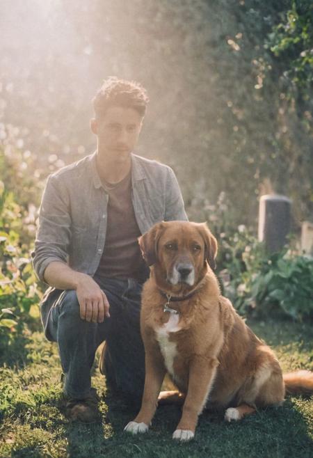 cinematic film still fashion photography portrait of 1man with dog as companion, grainy, headshot, sunlight , Fine Art & Beauty Photography – ,,light diffraction in frame, dreamy,hazy look.  Helios 44-2 lens mounted on a Praktica MTL 5B Helios 44M-4 lens, 58mm f/2,   in a garden.