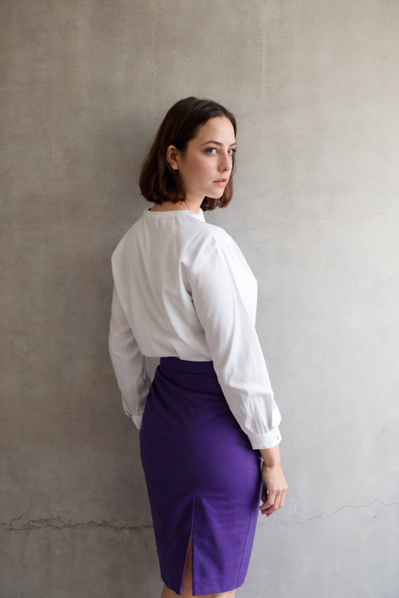 1girl, a woman in a white blouse and purple pencil skirt standing in an empty room, simple cement wall in the backdrop, from behind, look back, detailed face
 <lora:ks92_uk_lora_v01:1> ks92