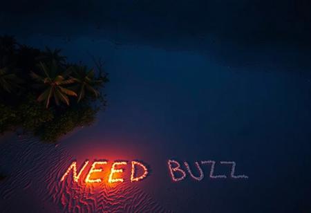 aerial view of tropical desert island beach in night. There is written text on beach sand with fire by a survivor "NEED BUZZ"