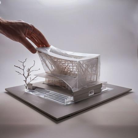 Professional RAW photography in a studio, showcasing an iconic concert hall model, lora:ModelMaker-XL:0.65, a masterpiece by Frank Gehry. This architectural marvel is made from {Graphene|Aerogel|Metamaterials|Nitinol|Quantum Dots|Carbon Nanotubes|Transparent Aluminum|Shape-memory Polymers|Bio-concrete}, blending art with acoustics. The scene s {a curator s hand gently touching the model|pastel surroundings} enhance its majestic silhouette. Diffused studio rim lighting meticulously reveals every detail, captured with unrivaled professional photography lora:xl_more_art-full_v1:0.5.