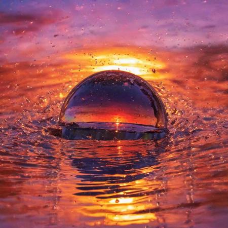 half angle, slightly from the side, warping of time and space, camera lens half way emerging from water, semi submerged rising through the water, with the most beautiful reflection of the colorful sunset, water droplets, refracting colorful light, color burst, explosion, fused, color bomb,