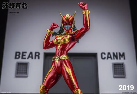 Center stage stands the Cyber Angel woman Dakini, vibrant in red and gold, poised for action with one arm uplifted. Her helmet, bearing a red visor and gold emblem, matches the striking color scheme. The backdrop, Bear's Boot Camp, provides a stark contrast. Top left, "Kamen Rider" is inscribed, while the bottom right corner reads "2019". The figurine, in high resolution, is the focal point, exuding energy and movement with its dynamic pose. The contrasting colors, text, and background offer context and intrigue. The image is a celebration of the character and anime, enhanced with vivid emotions, sharp details, and captivating lighting.