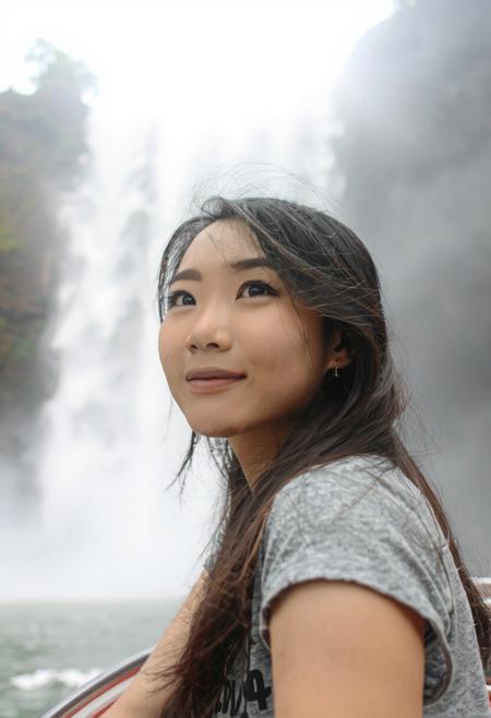lovely Asian woman at Iguazu Falls, Argentina, in a boat near the base of the falls, looking up at waterfall coming down, mist covering everything, especially her face and hair hair. close up on face and falls.