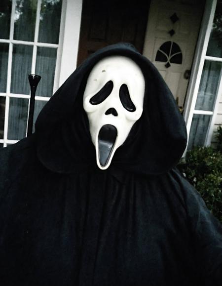 a cctv blurry image,(high-angle shot:1.3),(Ghostface is at porch taking a selfie outside a house:1.25),vhs filter,(low resolution:1.3),grainy,eerie,horror,dark