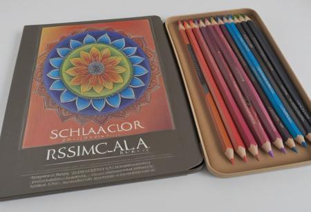 “Prismacolor Scholar” colored pencils (Box of 24), with an open mandala book which has started to be colored, pencils next to the book