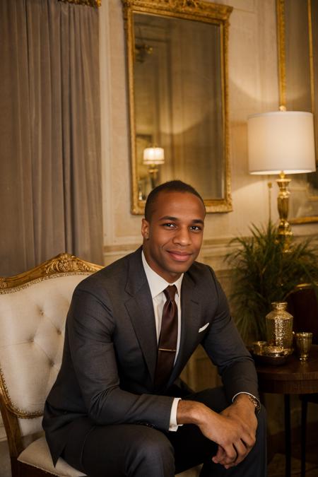 RAW Photo, photo of (light-skinned) African American man sc_chad3 <lora:sc_chad3-06:0.75> sitting introspectively in a booth in a Parisian-style cafe, contemplative smile, wearing charcoal tailored (tom ford suit) with ivory dress shirt and silk burgundy gucci tie with gold accents, deep mahogany walls,  ambient glow, dim interior, soft daylight filtering through lace curtains,serene atmosphere, nostalgic atmosphere, (vanity fair magazine), (photo by Sebastião Salgado)