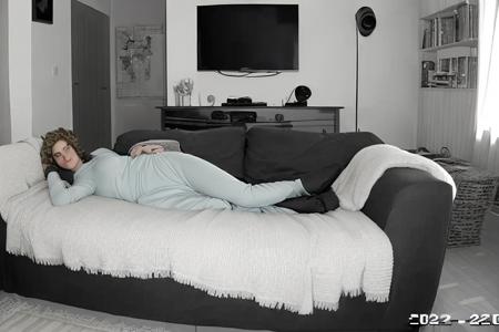 a man and a woman laying on a blanket in a living room with a couch and a television set, (style_cctv:0.9)