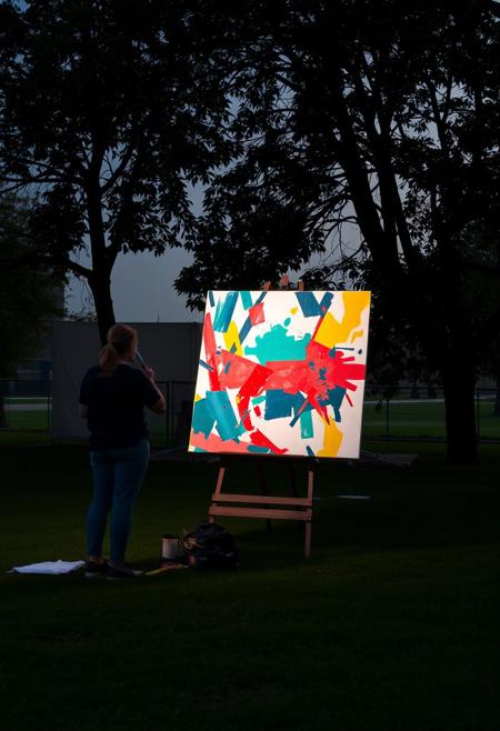 An artist painting outdoors, surrounded by light and color, yet their fragmented brushstrokes and shifting focus suggest a mind caught between order and transformation., conceptual, thought-provoking, minimalist, social identity, belief systems, architectural elements, text-based installations, illuminated text, human interaction, built environment, striking visual impact, cultural narratives, clean compositions, reflective