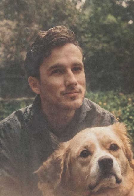 cinematic film still fashion photography portrait of 1man with dog as companion, grainy, headshot, sunlight , Fine Art & Beauty Photography – ,,light diffraction in frame, dreamy,hazy look.  Helios 44-2 lens mounted on a Praktica MTL 5B Helios 44M-4 lens, 58mm f/2,   in a garden. authentic happy smile