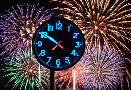 clock, closeup, fireworks in lower frame, bright flashing light, colors