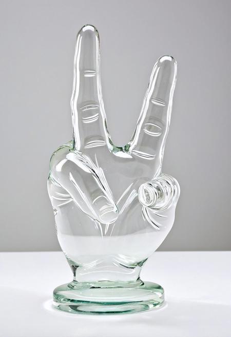 A clear glass sculpture showing the middle finger