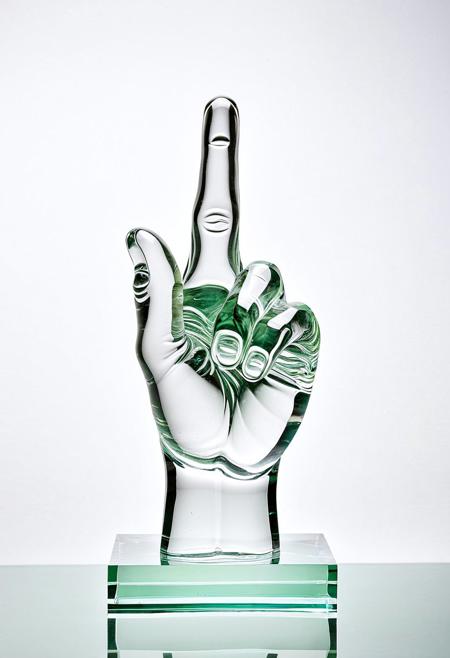 A clear glass sculpture showing the middle finger
