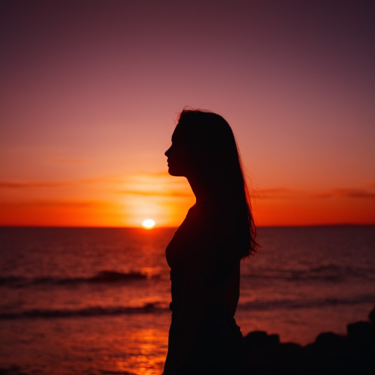 cinematic film still of  <lora:silhouette style v2:1>
A silhouette photo of a woman standing in front of a red sunset,1gir...