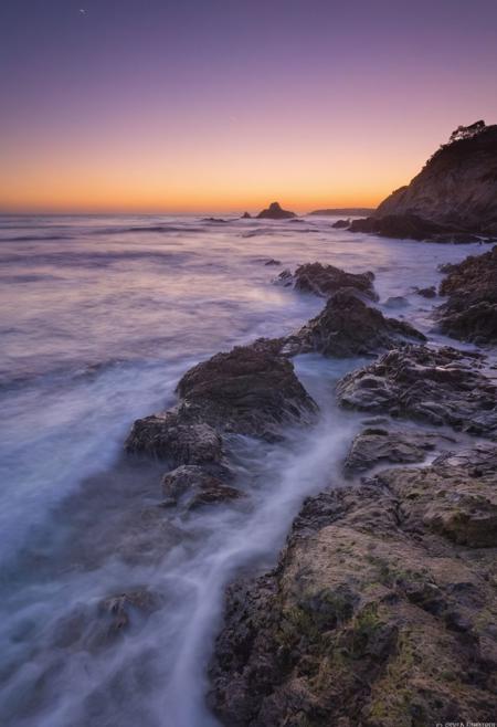 啎䥃佄䔀Capture the enchanting beauty of the transition from day to night, known as the blue hour, over a serene ocean with long exposure waves in the style of Michael Shainblum, using a Pentax K-1 Mark II camera with a Pentax D FA 24-70mm f/2.8 ED SDM WR lens. Position yourself to take advantage of the soft, diffused light of the twilight sky as it illuminates the ocean,