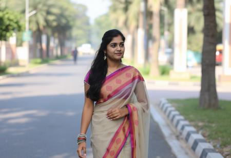 A young woman, Priya dressed in transparent saree walking along the road in her college