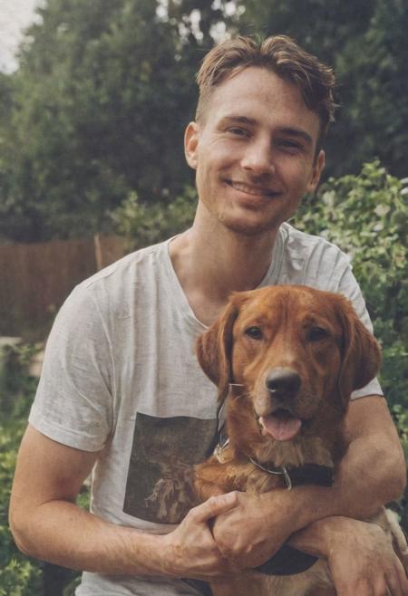 cinematic film still fashion photography portrait of 1man with dog as companion, grainy, headshot, sunlight , Fine Art & Beauty Photography – ,,light diffraction in frame, dreamy,hazy look.  Helios 44-2 lens mounted on a Praktica MTL 5B Helios 44M-4 lens, 58mm f/2,   in a garden. authentic happy smile