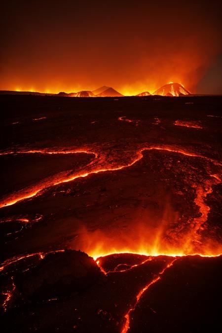 vast scorched wasteland, blood-red skies, ruined city in the distance, burning wreckage scattered across the ground, volcanic cracks glowing with lava, dried rivers of ash, cinematic lighting, ultra-wide composition, high detail terrain