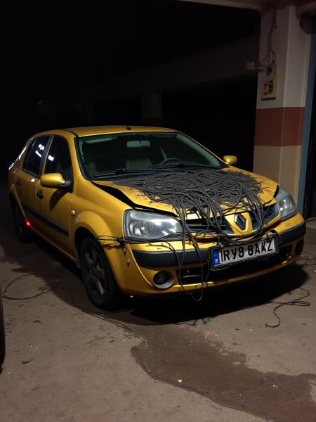 Infected renault logan shot. Russian town's garages area with one damaged renault logan, which appears to be possessed and infected with evil cybernetic infection, that covers half of the car with it's destructive tubes and wires. Cybernetic infection has a subtle red glowing accents. Night, dark environment. Accident photo, made in hurry and slightly blurred. Cheap android photo, posted on Facebook in 2010.