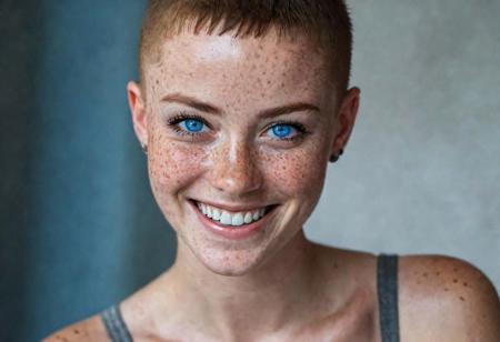 beautiful lady, (freckles), big smile, blue eyes, buzzcut hair, dark makeup, hyperdetailed photography, soft light, head and shoulders portrait, cover as laracroft