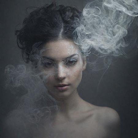 An abstract masterpiece, vibrant tendrils of smoke, intricately detailed and shrouded in mystique, conjuring a sense of fantasy. Within this ethereal realm lies a delicate fusion of beauty, cuteness, discretion, and elegance. The translucent visage of a face emerges, veiled in a subtle mask, adding an enigmatic touch to the composition. The artwork invites viewers to immerse themselves in the beauty of the unknown, where the ethereal and the elegant converge in a captivating dance of elements.