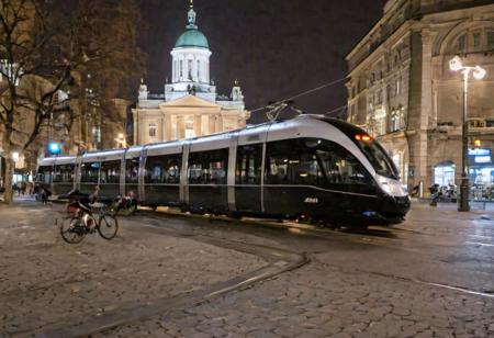 Raw photo,( shallow depth of image:1.2), (minimalistic:1.4), outdoors, wide shot of the downtown of Helsinki, tram, bike riders, night, black bullet train, 38 mm photograph, professional, FOV, HDR, natural lighting, motion blur, lowfi, KodakPhotoMaybe, Photographer Reuben Wu Style