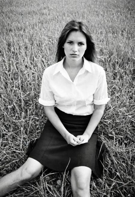 european woman 25 years sitting in a grass field, black skirt, white shirt,from top,half body,ilford hp5 analog film, artsy, harsh shadows, ultra wide angle, contact test, damaged print,flash,overexposed, faded, grainy,blurry, pixelated, motion blur, vignette