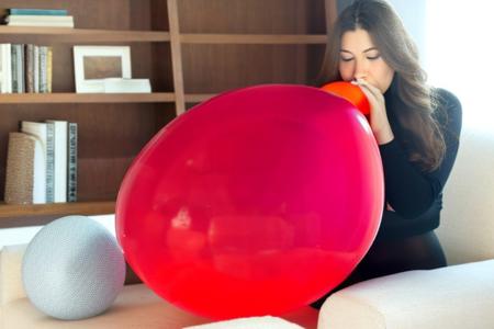 highest resolution photo, 18yo, french female, (((blowing up a huge balloon))), slender shape, (small breasts)+, daytime, red shirt, turtleneck, short sleves, cut-out cleavage, tight fitted shirt, erect nipples visible under her shirt, long pants, black flared pants, lycra jazz pants, tight fitting pants, oval face, big nose, long hair, dark hair, wavey hair, in modern living room, big windows in background, plants, sofa, shelves with books, soft lighting, ultra realistic photo, highly detailed clothing, cameltoe+
