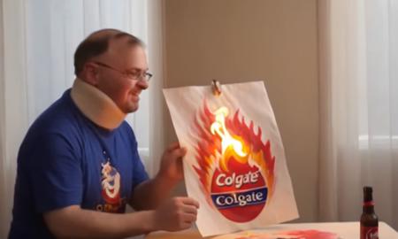 Impressionist painting of  <lora:Tourettes_Guy:.95> Tourettes Guy is burning a poster for Colgate , loose brushwork, vibrant color, light and shadow play, captures feeling over form