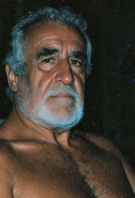grainy nighttime lowlight photograph, dark room,
masterpiece, 4k, solo, alone, 
tall old hairy tanned grandpa with hairy chest, bullish chubby face with doublechin, face portrait, bushy eyebrows, wide big nose, big thick neck, muscular neck,
father, vater, uncle, onkel, stepdad, stiefvater, grandpa, opa,
gentle charming expression, romantic, intimate, 
sitting in a chair in a dark cloister chapel,