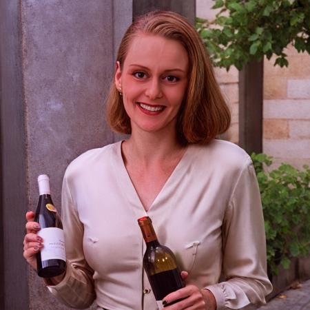 Talia Winters, stylish blouse, in Paris, on holiday, grinning, holding a bottle of wine <lora:Talia Winters B5 XL:1>