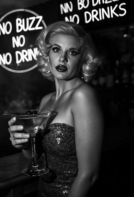 Film noir style, black & White, high contrast, greyscale:2.5, 1940s film noir detective movie, shot on film, film noir detective movie, cinematic, 
((best quality)), ((masterpiece)), (detailed), film noir butterfly lighting, 
Female, beautiful voluptuous woman, platinum blonde hair in 1940s pinup style, full pouty lips, lips parted, busty, hourglass figure:0.7, slinky strapless and sleeveless dress, super sexy sequin dress, standing at a bar in a cocktail lounge, Smokey background:0.6, neon Sign says “NO BUZZ NO DRINKS”:2.5, highly detailed skin, looking at the viewer,  holding a martini glass, background of a bar, backlit bottles of upscale alcohol on shelves behind bar:0.6, no watermark signature, closed mouth, insanely detailed, ((masterpiece)), HDR, key visual, studio quality, highly detailed,close portrait,
beautiful, ultrafine, detailed, studio lighting . Monochrome, high contrast, dramatic shadows, 1940s style, mysterious, cinematic, film noir:0.9,
