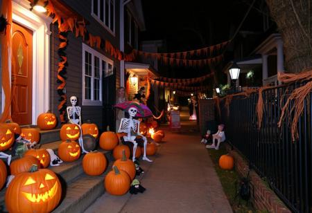 On a Halloween night, the street is full of Halloween elements. There are pumpkins everywhere, some carved into grotesque faces with sharp teeth and triangular eyes. Skeletons made of plastic are placed at the entrances of some houses. Witch broomsticks lean against the walls. Orange and black streamers flutter in the breeze. Haunted - looking dolls are scattered on the steps. There are also fake spiders and their webs clinging to the fences.