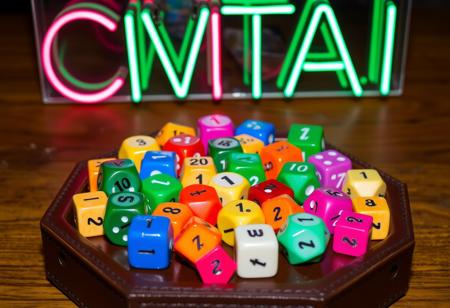 Many colorful polyhedral dice sit on a hexagonal leather dice tray. All of the dice show the number "1" on their top face.  A neon sign reads "CIVITAI" above.