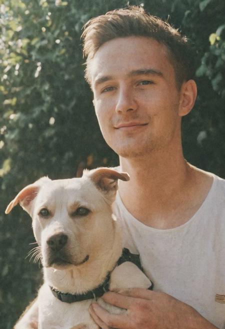 cinematic film still fashion photography portrait of 1man with dog as companion, grainy, headshot, sunlight , Fine Art & Beauty Photography – ,,light diffraction in frame, dreamy,hazy look.  Helios 44-2 lens mounted on a Praktica MTL 5B Helios 44M-4 lens, 58mm f/2,   in a garden. authentic happy smile