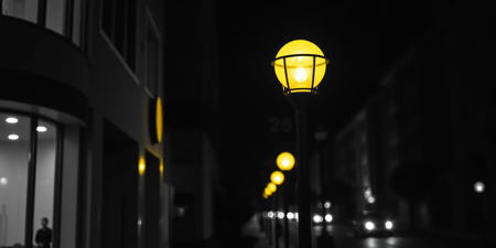 Selective Colouring photo of a close up of a city street at night, yellow street light, monochrome