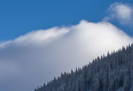 Dense clouds on top in the mountains during the day in winter.